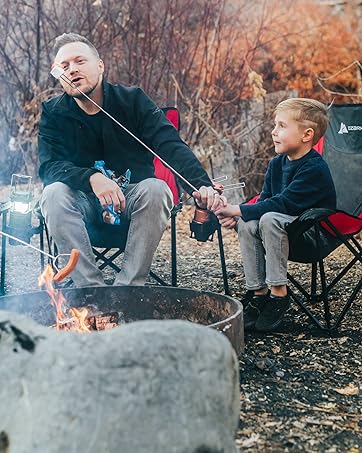 father and son enjoying smores sticks around a fire pit